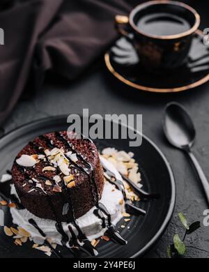 Teller mit frischen Brownies und Eis auf schwarzem Teller Stockfoto