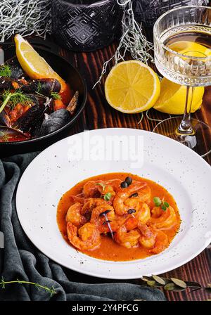 Garnelen in Romesco-Sauce und Muscheln auf Holz Stockfoto