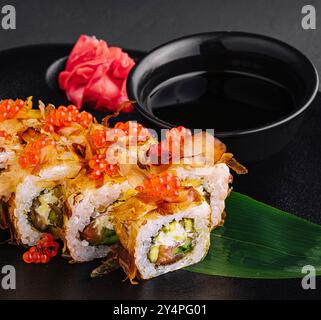 Sushi-Brötchen mit Bonito-Flocken, Thunfisch, Käsecreme und Gurke Stockfoto