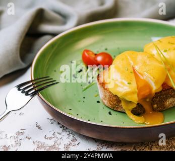 Klassisches Ei benedikt auf grünem Teller Stockfoto