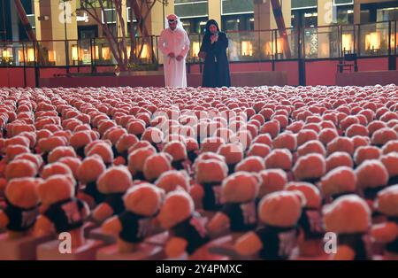 Doha, Katar. September 2024. Menschen besuchen die Installation von Teddybären mit dem Titel "Echo der verlorenen Unschuld" in der Freiluftgalerie Barahat Mashaireb, um auf palästinensische Kinder aufmerksam zu machen, die beim israelischen Angriff auf Gaza am 18. September 2024 in Doha, Katar, ums Leben gekommen sind. Die Installation mit 15.000 Teddybären wurde vom syrischen Künstler Basher Mohamad entworfen. Die Ausstellung läuft bis zum 26. September. (Foto: Noushad Thekkayil/NurPhoto) Credit: NurPhoto SRL/Alamy Live News Stockfoto