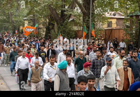 Die Anhänger der Bharatiya Janata Party gehen nach der Rede von Premierminister Narendra Modi mit Parteiflaggen vor den Veranstaltungsort. Mit der Kundgebung von Premierminister Modi in Srinagar will die BJP Unterstützung für ihre Kandidaten im Tal gewinnen, wo die Partei nie einen Sitz gewonnen hat. Einen Tag nach der ersten Phase der Parlamentswahlen in Jammu und Kaschmir mit einer Wahlbeteiligung von 59 % sprach Modi an einer öffentlichen Kundgebung im Sher-e-Kaschmir-Stadion. Von den 47 Sitzen in Kaschmir hat die BJP Kandidaten in 19 Wahlkreisen aufgestellt, weniger als ein Drittel der Gesamtbevölkerung und weniger als bei den Parlamentswahlen 2014. Stockfoto