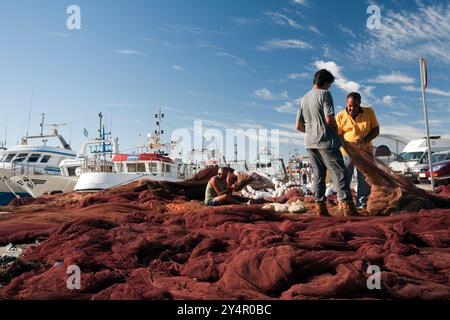 Sevilla, Spanien, 7. August 2008, Fischer arbeiten zusammen, um Netze unter klarem Himmel am Hafen Bonanza in Sanlucar de Barrameda, Cadiz, Andalusien, zu reparieren. Stockfoto