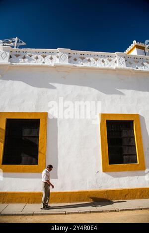 Sevilla, Spanien am 15. August 2007 spaziert Ein Mann nachdenklich entlang der hellen weißen Wände der echten Maestranza-Stierkampfarena in Sevilla unter einem klaren blauen Himmel. Stockfoto