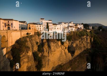 Farbenfrohe weiß getünchte Häuser stehen am Rande der beeindruckenden El Tajo Schlucht in Ronda und zeigen atemberaubende andalusische Architektur. Stockfoto