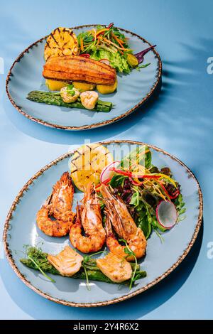 Lachssteaks und Garnelen mit gekochtem Spargel braten Stockfoto