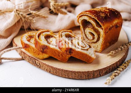 In Scheiben geschnittenes Brötchen mit Apfelmarmelade auf Holzbrett Stockfoto