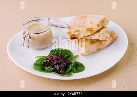 Hähnchenpastete mit Zwiebelmarmelade und Pitabrot auf einem weißen Teller serviert Stockfoto