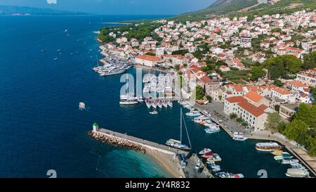 Der Hafen von Brac Island liegt an der malerischen Küste und bietet farbenfrohe Boote und bezaubernde Gebäude, Bol Brac Island Kroatien Stockfoto