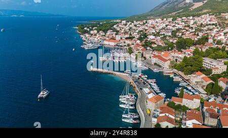 Ein atemberaubendes Panorama zeigt den bezaubernden Hafen der Insel Brac, gesäumt von Segelbooten und umgeben von malerischen Häusern, der Insel Bol Brac Kroatien Stockfoto