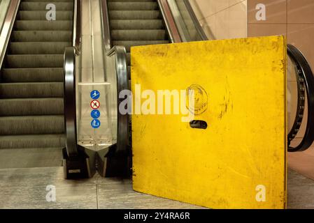 Die unterirdische U-Bahn-Rolltreppe ist aufgrund von Reparaturen aufgrund von Instandhaltungsarbeiten durch gelbe Barrieren blockiert Stockfoto