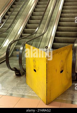 Die unterirdische U-Bahn-Rolltreppe ist aufgrund von Reparaturen aufgrund von Instandhaltungsarbeiten durch gelbe Barrieren blockiert Stockfoto