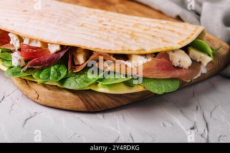 Piadina: Klassisches italienisches Tortilla-Brot mit Schinken, Basilikum und Dor Blue Stockfoto