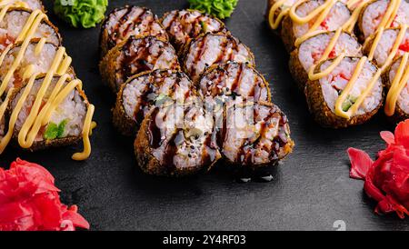 Set gebackene Sushi-Brötchen mit Wasabi und Ingwer auf Schwarz Stockfoto