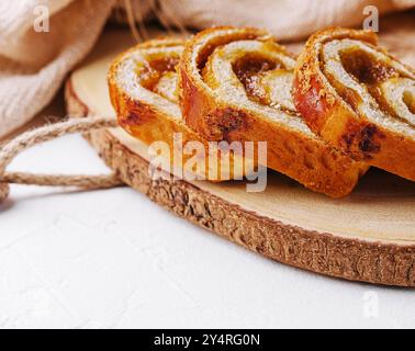 In Scheiben geschnittenes Brötchen mit Apfelmarmelade auf Holzbrett Stockfoto