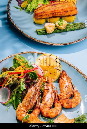 Lachssteaks und Garnelen mit gekochtem Spargel braten Stockfoto