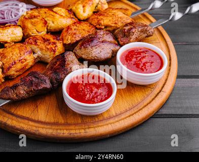 Metallspieße mit köstlichem Fleisch und Ketchup-Sauce Stockfoto