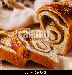 In Scheiben geschnittenes Brötchen mit Apfelmarmelade auf Holzbrett Stockfoto