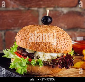 Amerikanischer Cheeseburger mit Pommes frites auf Holzbrett Stockfoto