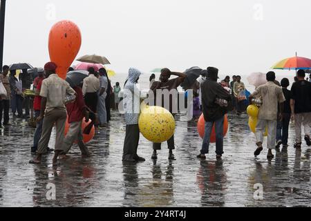 Mumbai, Maharashtra / Indien - 11. Juni 2008: Der Blick auf einige Männer, die mit Ballons auf der Straße stehen, um während des Regens in der Nähe von Gateway of India zu verkaufen. Stockfoto