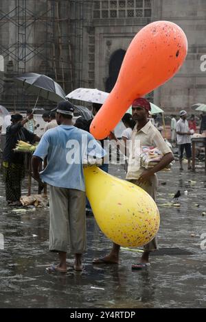 Mumbai, Maharashtra/Indien - 11. Juni 2008: Der Blick auf die beiden Männer, die während des Regens auf der Straße mit Ballonen stehen. Stockfoto