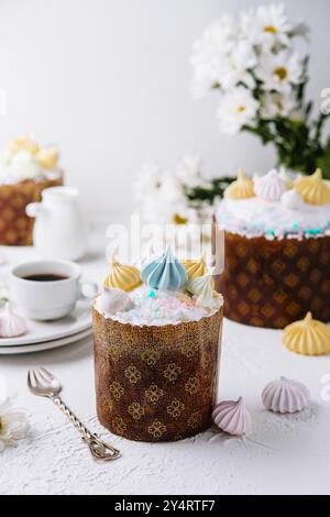 Traditionelles osterkulich mit Pastell-Zuckerguss und Merengues, serviert mit Tee Stockfoto