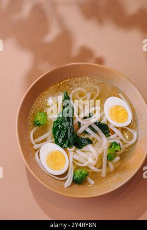 Eine warme Schüssel Udon-Nudelsuppe mit halbem Ei und frischem Gemüse Stockfoto