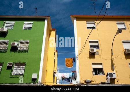 In den bunten Gebäuden im Stadtteil Pío XII finden Sie Trockenwäsche unter einem klaren blauen Himmel in Sevilla. Stockfoto