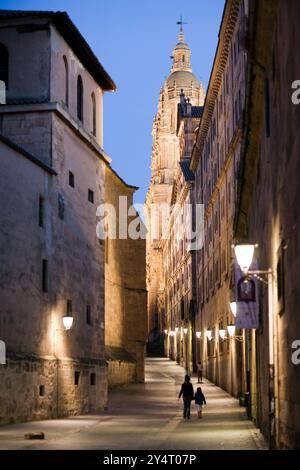 Besucher schlendern durch die Calle de la Compañía und bewundern die historische Architektur, während die Universität Pontifica und die Türme von Clerecía die Abenddämmerung erleuchten. Stockfoto