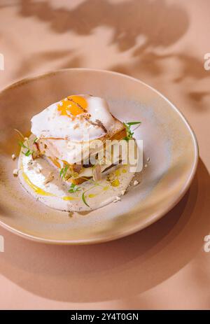 Elegante Präsentation eines Frühstückspakets mit perfekt gekochten, sonnigen Ei und Kräutern Stockfoto