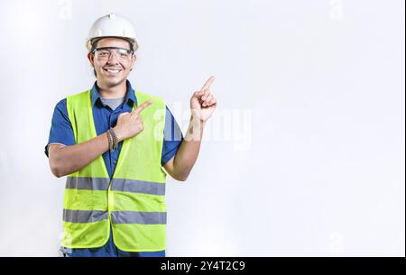 Glücklicher männlicher Ingenieur, der auf die isolierte Seite zeigt. Lächelnder männlicher Ingenieur, der auf einen leeren Raum zeigt Stockfoto