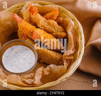 Köstliche Anordnung knuspriger gebratener Garnelen mit Tatarensauce in Korbkörben Stockfoto