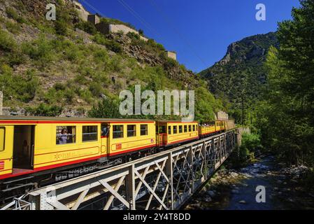 Der kleine gelbe Zug (Le Petit Train Jaune) führt durch Villefranche-de-Conflent, Frankreich, Europa Stockfoto