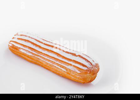 Zartes Eclair mit Glasur auf einer weißen Platte, isoliert mit Schneidepfad Stockfoto