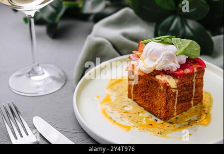 Elegantes Brunch-Ambiente mit herzhaftem Toast, garniert mit einem delikaten pochierten Ei und einer Sauce Stockfoto