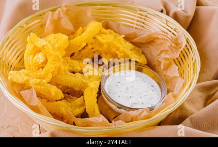 Köstliches Arrangement knuspriger gebratener Garnelen mit Tatarensauce und goldenen Chips in Korbkörben Stockfoto