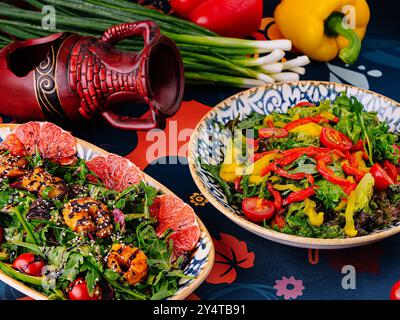 mediterrane Gerichte auf einer gemusterten Tischdecke mit frischem Gemüse und Einrichtung Stockfoto