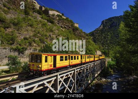 Der kleine gelbe Zug (Le Petit Train Jaune) führt durch Villefranche-de-Conflent, Frankreich, Europa Stockfoto