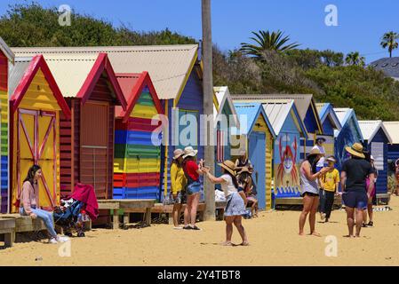 Menschen, die Spaß am Brighton Beach mit bunten Badekästen als Hintergrund in Melbourne, Victoria, Australien, Ozeanien haben Stockfoto