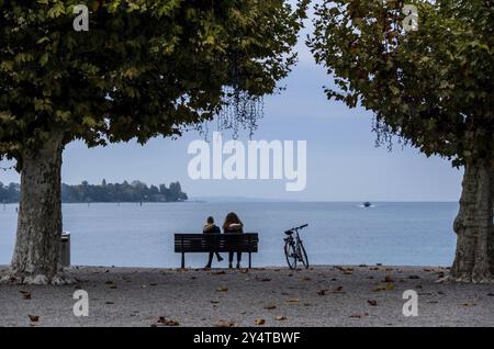 Konstanz am Bodensee. Zwei Leute sitzen auf einer Bank und blicken über das Wasser Stockfoto