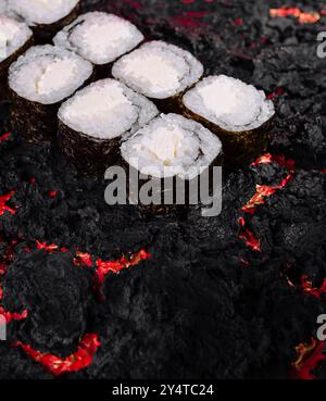 Künstlerische Präsentation von Sushi-Rollen vor einem lebendigen Hintergrund mit geschmolzener Lava-Struktur Stockfoto