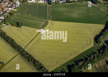 Kleines Flugzeug über grünen Feldern. Sportflugzeug Stockfoto