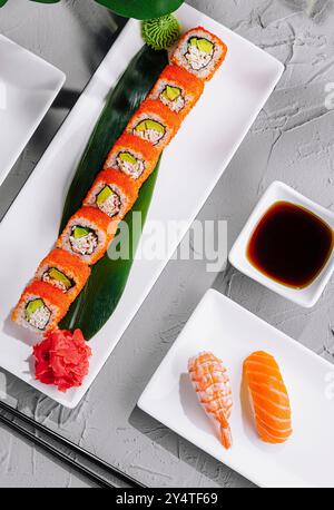 Exquisite Sushi-Auswahl, kunstvoll auf modernen Tellern mit tropischem Blattdekor Stockfoto