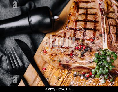 Ein großes gegrilltes Steak auf einem Holzteller mit Blick von oben Stockfoto