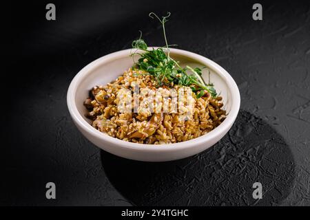 Gourmet-Reis serviert in einer weißen Schüssel, garniert mit frischen Kräutern, perfekt für kulinarische Konzepte Stockfoto