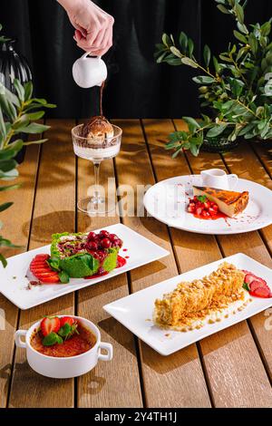 Person, die Soße auf Eis tränkt und eine Auswahl an eleganten Desserts serviert Stockfoto