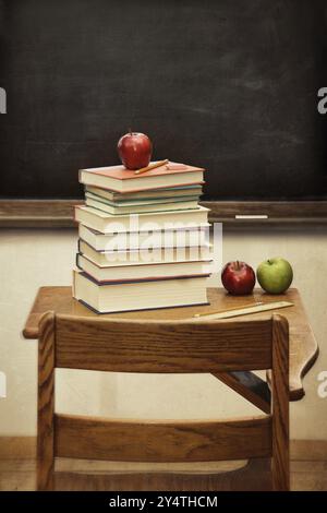 Alte Schreibtisch mit einem Stapel Bücher und Apple mit Vintage Look Stockfoto