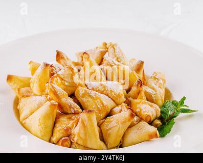 Köstliche glasierte Äpfel Pfannkuchen, garniert mit einem Minzblatt, serviert auf einem sauberen weißen Hintergrund Stockfoto