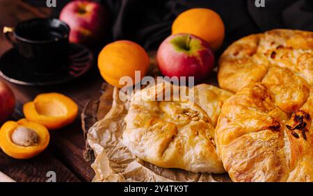 Frisch gebackene Pfirsichgalette mit reifem Obst und einer Kaffeetasse auf einem rustikalen Küchentisch Stockfoto