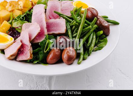 Lebendiger und nahrhafter Nicoise-Salat mit gebratenem Thunfisch, Gemüse, Eiern und Kartoffeln Stockfoto